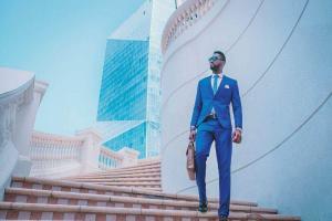 Man in a blue suit walking down stairs in a business district | Guide My Growth