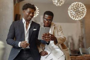 Businessmen looking at a tablet | Guide My Growth