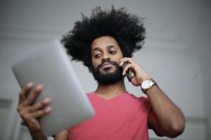 Man with phone and tablet | Guide My Growth